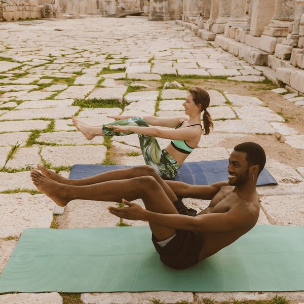 Diverse group of people smiling and preparing for a yoga session.