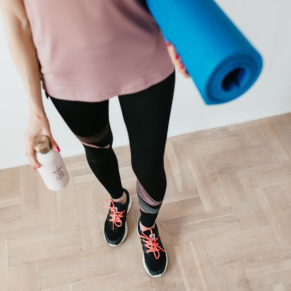 Yoga mat rolled out next to a water bottle and a small towel.